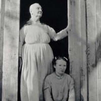 Emma Dusenbury and her daughter in the doorway of their home, as featured in the poster for the folk music exhibit from Special Collections.